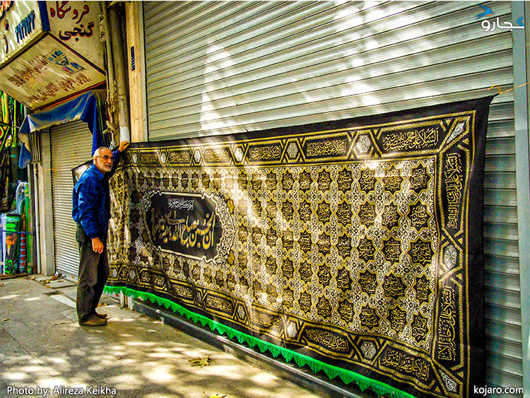 پرچم بزرگ مشکی عزاداری محرم بر سر در مغازه در بازار پرچم تهران