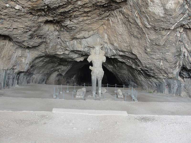 مجسمه سنگی باستانی در مقابل ورودی غار شاپور