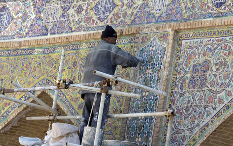پیرمرد در حال مرمت کردن نقش و نگاره های مسجد جامع شهرکرد