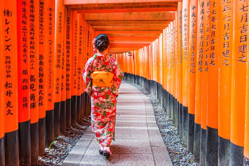 دیوارهای نارنجی و بانوی ژاپونی در فوشیمی ایناری کیوتو، ژاپن