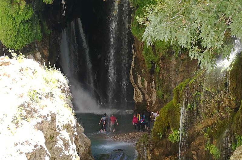 کودکان در حال بازی در اطراف آبشار آب ملخ