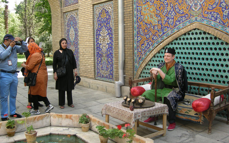 گردشگران در حال عکس گرفتن با لباس قاجاری در کاخ گلستان
