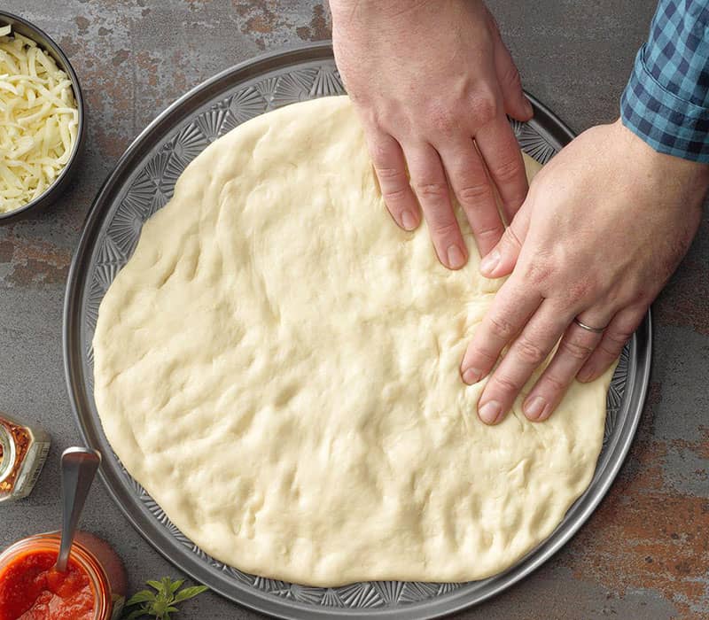 پهن کردن خمیر پیتزا در قالب
