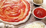 مالیدن سس گوجه روی خمیر پیتزا