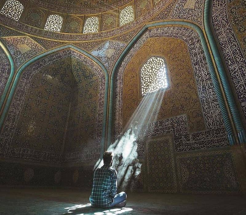 شخصی در حال نیایش در شبستان مسجد شیخ لطف الله