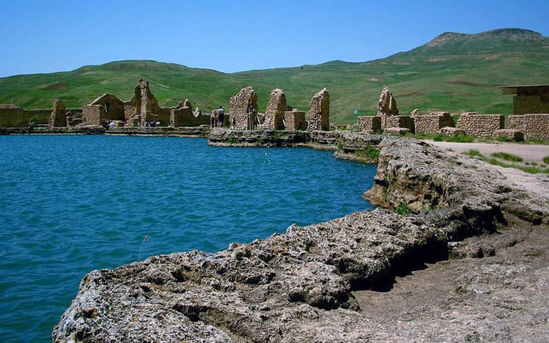 دریاچه ای آبی رنگ با بقایای بناهای تاریخی در اطرافش