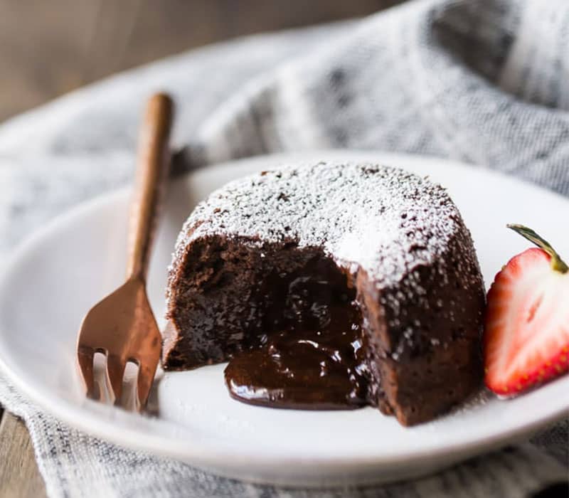 کیک شکلاتی مذاب با تزیین پودر قند و توت فرنگی