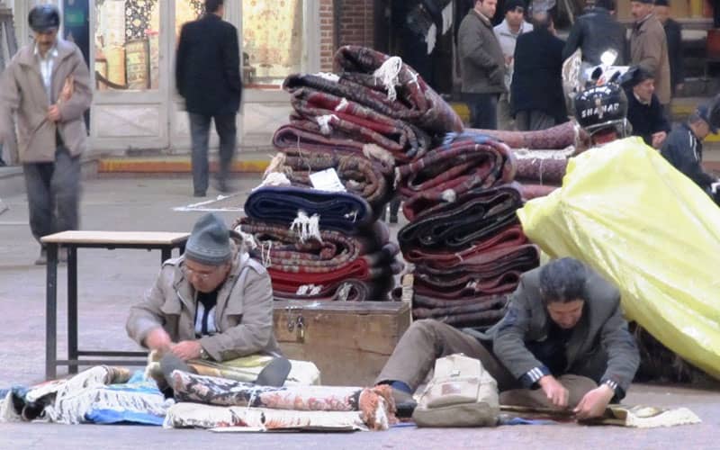 افرادی مشغول مرمت فرش در بازار تبریز