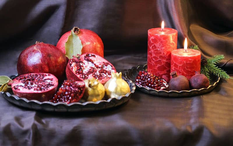 سینی انار و شمع قرمز در شب یلدا