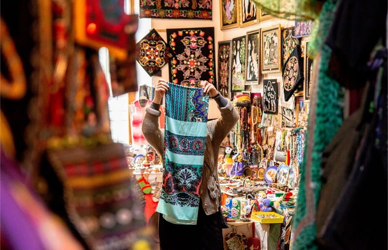 یک فروشنده در حال مرتب کردن روسری های سنتی باکو