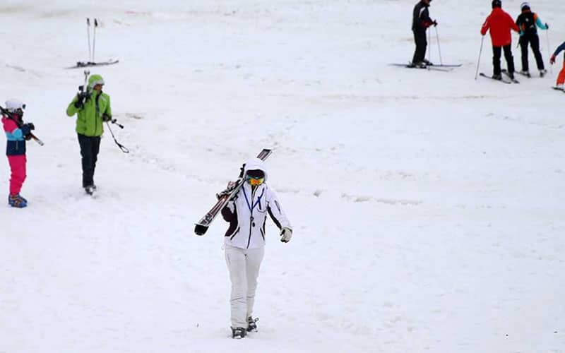 پیست اسکی و افرادی که در حال اسکی هستند