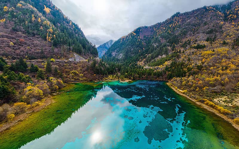 دریاچه ای به رنگ فیروزه ای و سبز در میان کوه ها