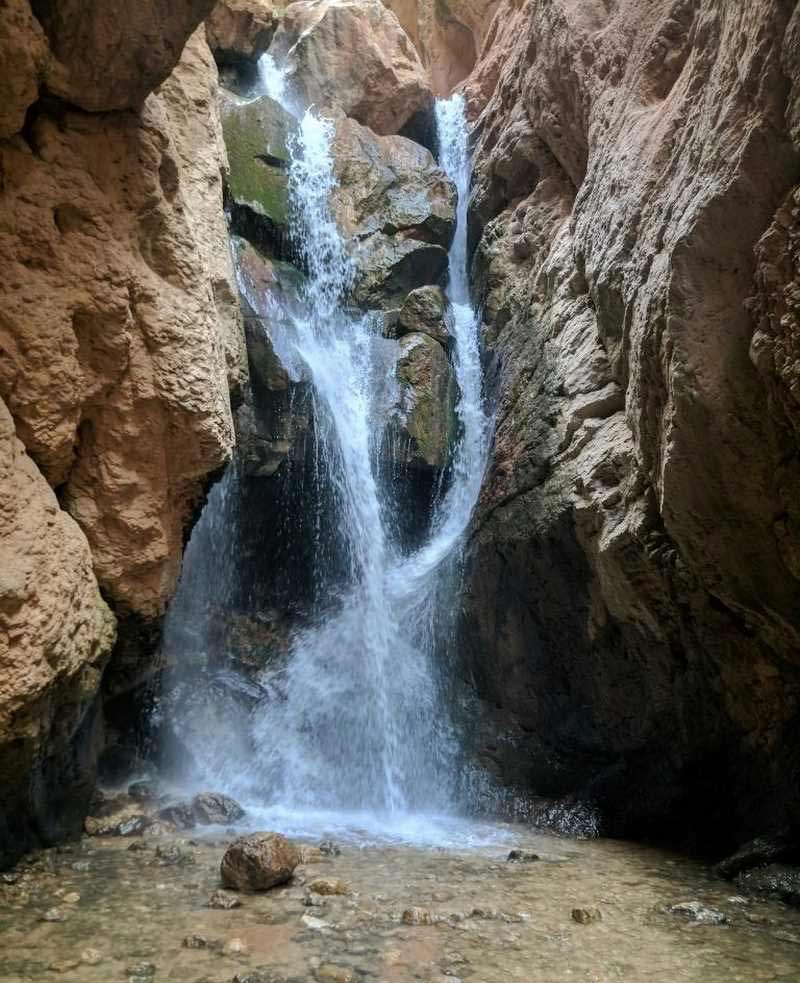منظره آبشار زیبای مجن در میان صخره‌ها