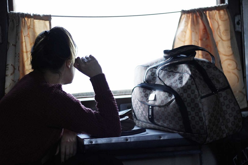 مسافر باکو در قطار با یک کیف در حال نگاه کردن به بیرون