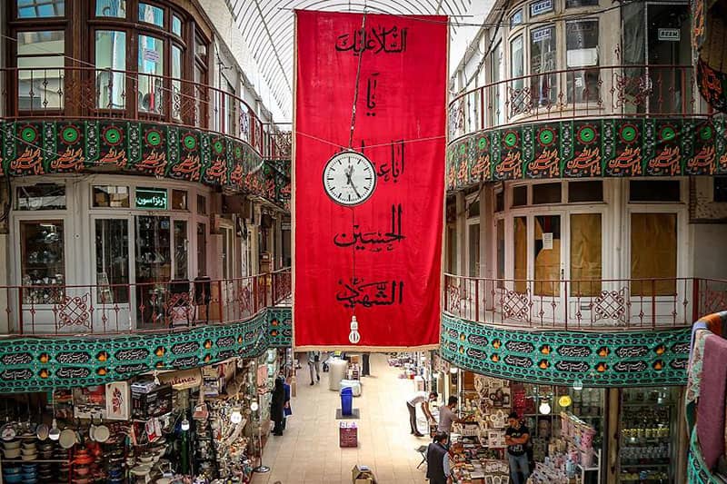 بازاری چند طبقه و قدیمی با پرچمی قرمز برای امام حسین