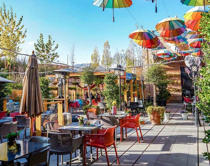 رستورانی با صندلی های رنگی و چترهای رنگارنگ 