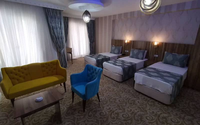 اتاق سه تخته هتل با دو مبل به رنگهای فیروزه ای و خردلی