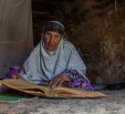 پیرزن در حال قرآن خواندن در روستای ماخونیک