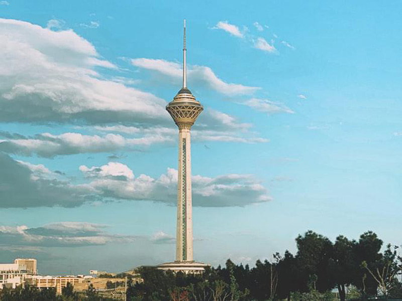 نمایی از برج میلاد تهران از دور میان درختان