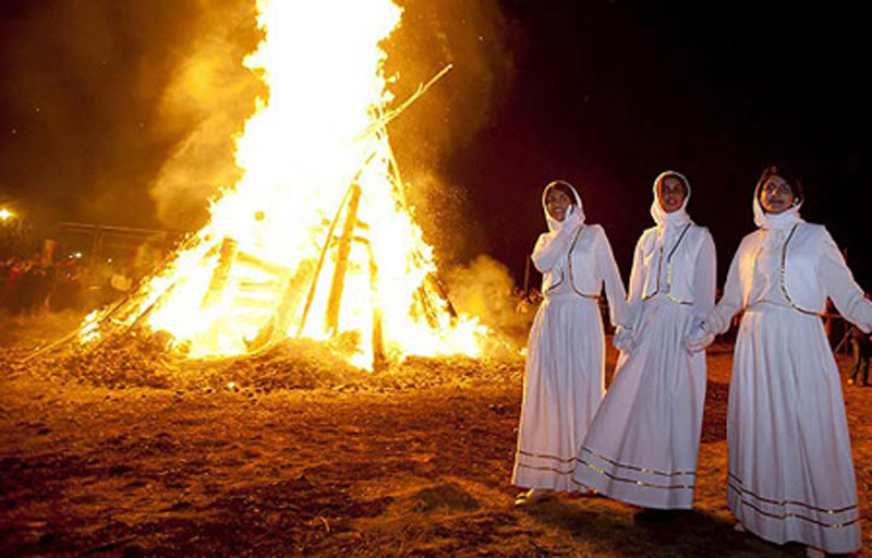 سه دختر زرتشتی سفیدپوش در کنار آتش جشن سده