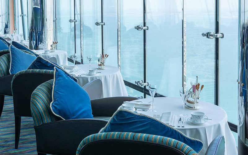 رستورانی با مبلمان آبی و پنجره های سرتاسری