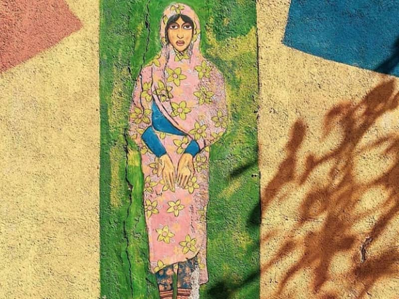 نقاشی زنی با پوشش جنوبی روی دیوار