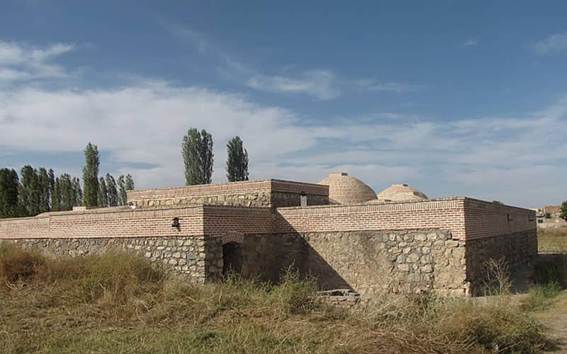 سازه ای تاریخی با دیوارهای سنگی و آجری و گنبد