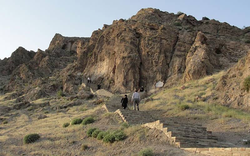 بازدید گردشگران از سنگ نگاره ای در دل کوه