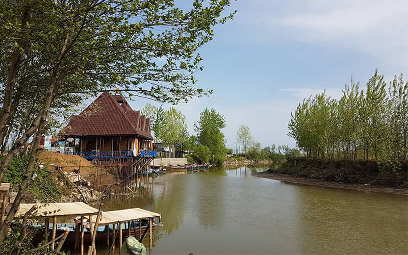 کلبه هایی در کنار رودخانه ای پرآب