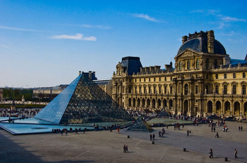 ورودی موزه لوور در پاریس با هرم مقابل آن از نمای دور