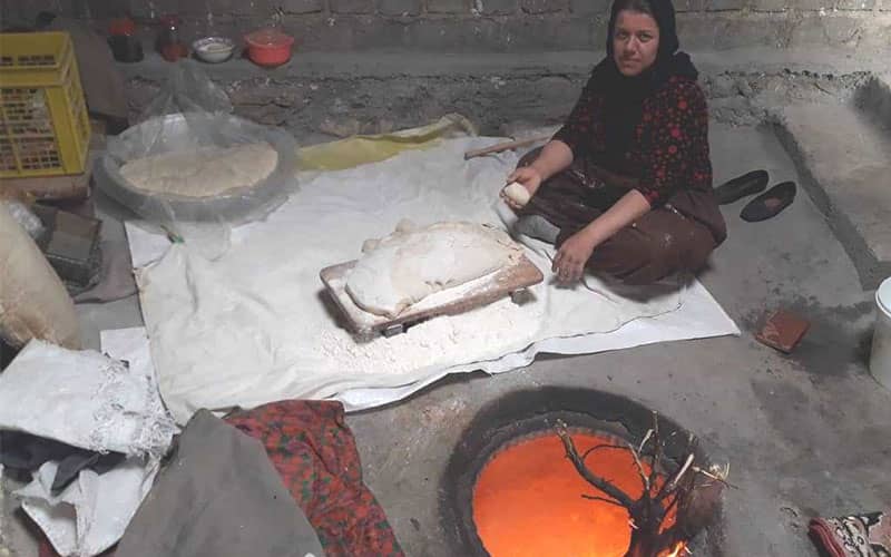 زنی جوان در حال پخت نان با تنور