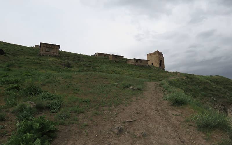 قلعه ای تاریخی و چندین بنای آجری بالای تپه