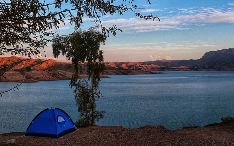 چادر مسافرتی در کنار دریاچه ای پرآب