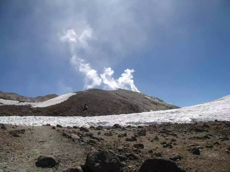 تصویر کوهنورد در قله تفتان با بخار دهانه کوه
