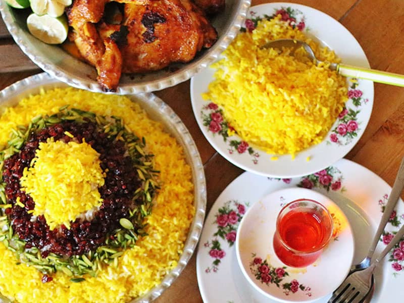 برنج زعفرانی در کنار مرغ و یک استکان چای