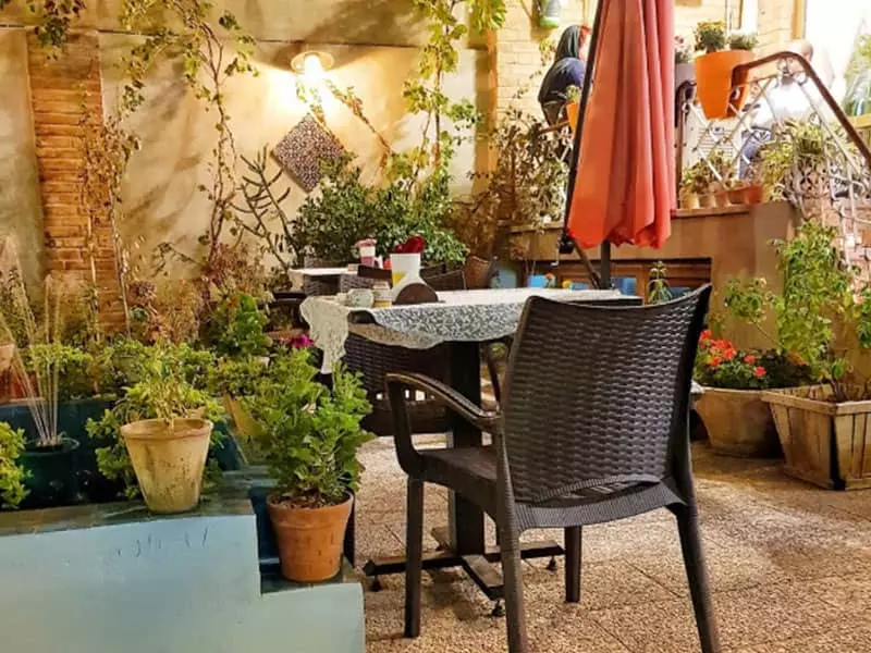 حیاط کافه آنسو با گلدان و سایبان