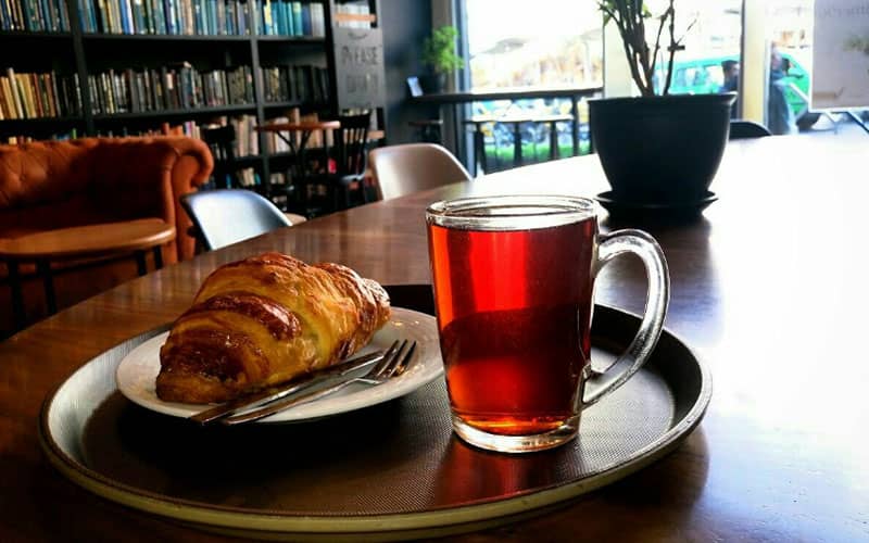 یک استکان چای همراه با کروسان در کافه لمیز