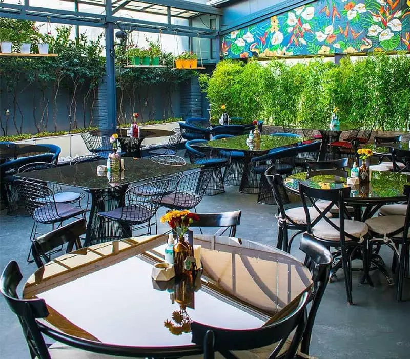 کافه روباز نگیما با مبلمان مدرن و درختچه های سرسبز