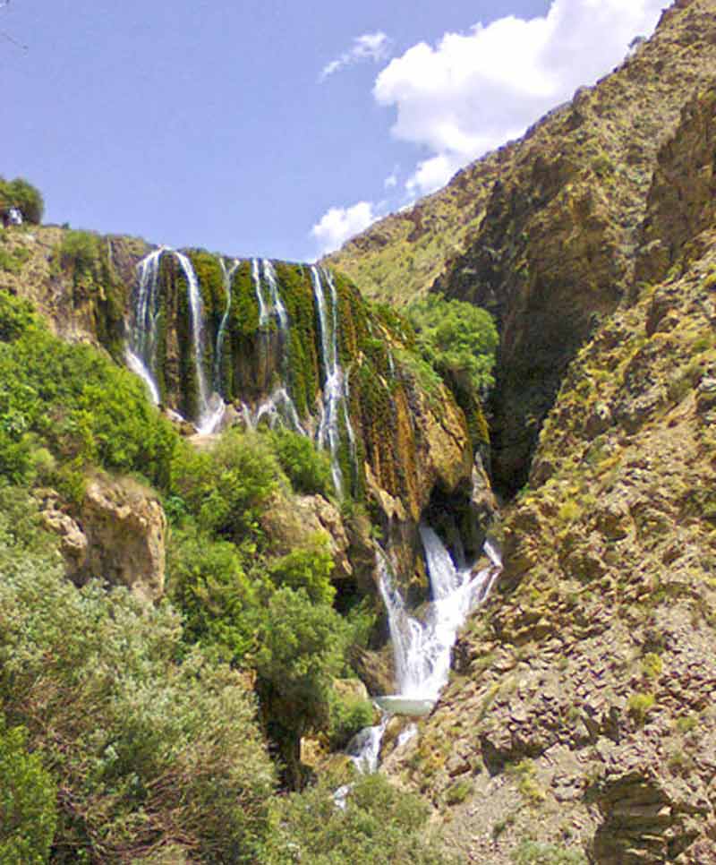 آبشار پونه زار بین کوه های پر درخت در اصفهان