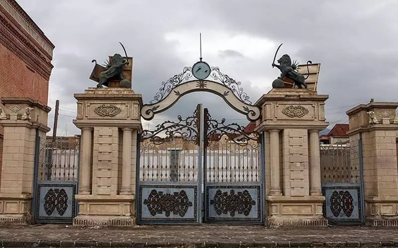دروازه ای قدیمی با دو مجسمه شیر و در بالای آن در شهرک غزالی