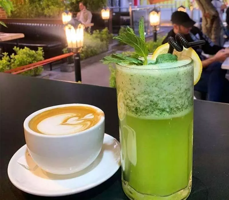 یک لیوان نوشیدنی سبزرنگ و یک فنجان قهوه در کافه پادنا