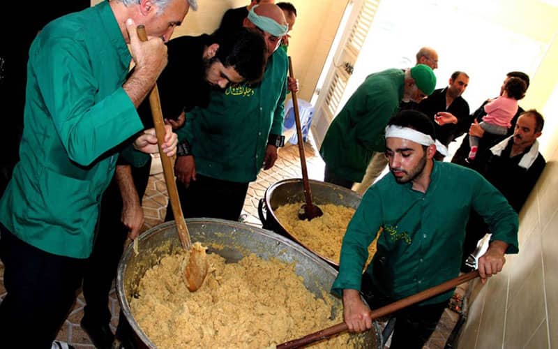 مردانی با لباس سبزرنگ در حال پخت حلوا