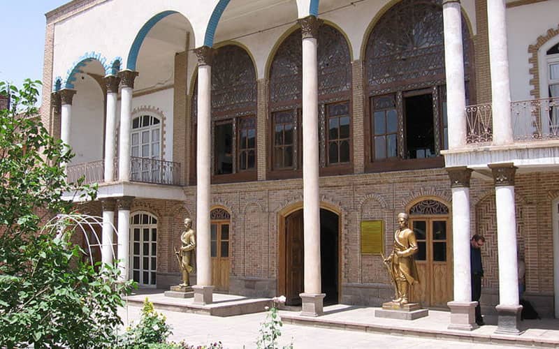 خانه مشروطه تبریز با ستون های بلند و دو مجسمه طلایی رنگ