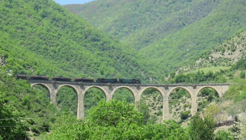 عبور قطار از پل بلند میان کوهستان های سرسبز در مسیر راه آهن سراسری شمال جنوب