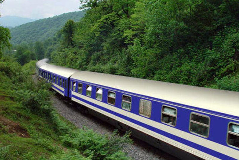 قطار در حال حرکت در پیچ جنگل های شمالی در مسیر ره آهن سراسری ایران
