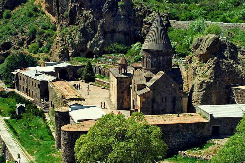 نمای کل ساختمان کلیسای گغارت و طبیعت سبز اطراف آن در ارمنستان