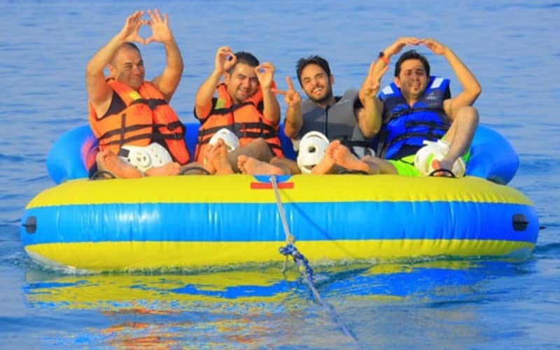 قایق بادی زرد و آبی رنگ با چهار مسافر مرد