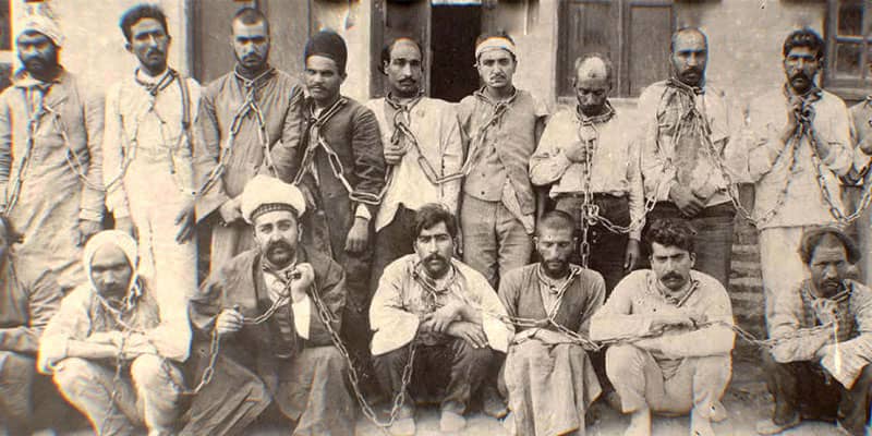 عکسی قدیمی از تعدادی مرد با زنجیر به گردن
