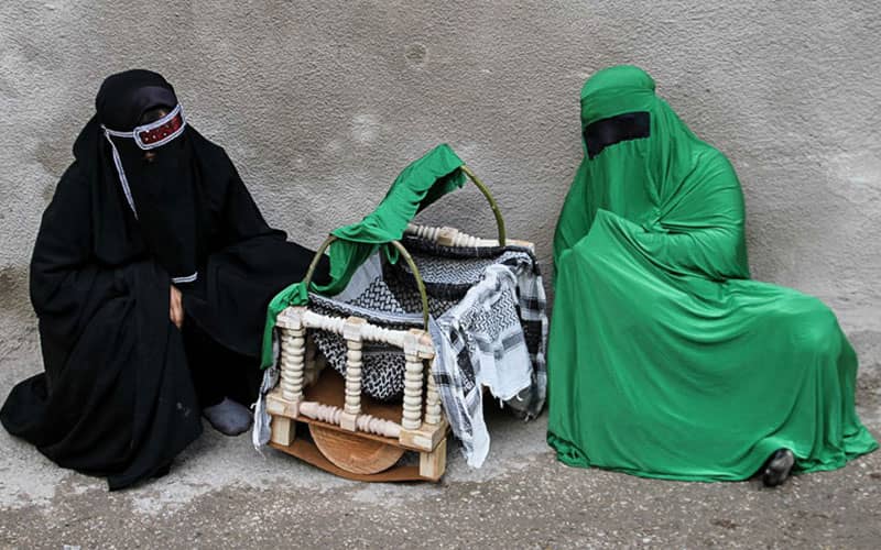 گهواره حضرت علی اصغر با دو نفر در لباس سبز و سیاه