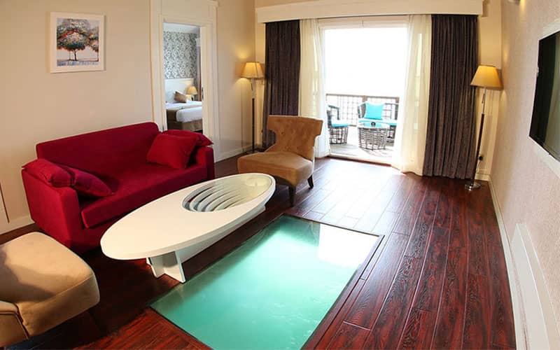 اتاقی با مبلمان رنگی و کف شیشه ای رو به دریا